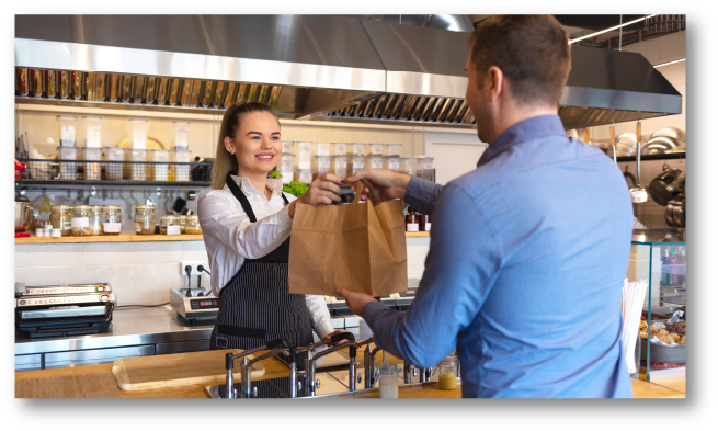 Women handing bag to man in restaurant